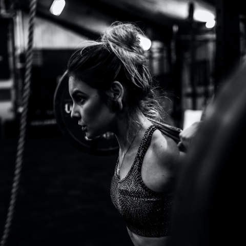 A girl preparing to do squats with a barbell.