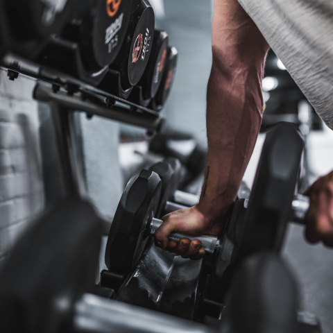 A man taking dumbbells from a rack